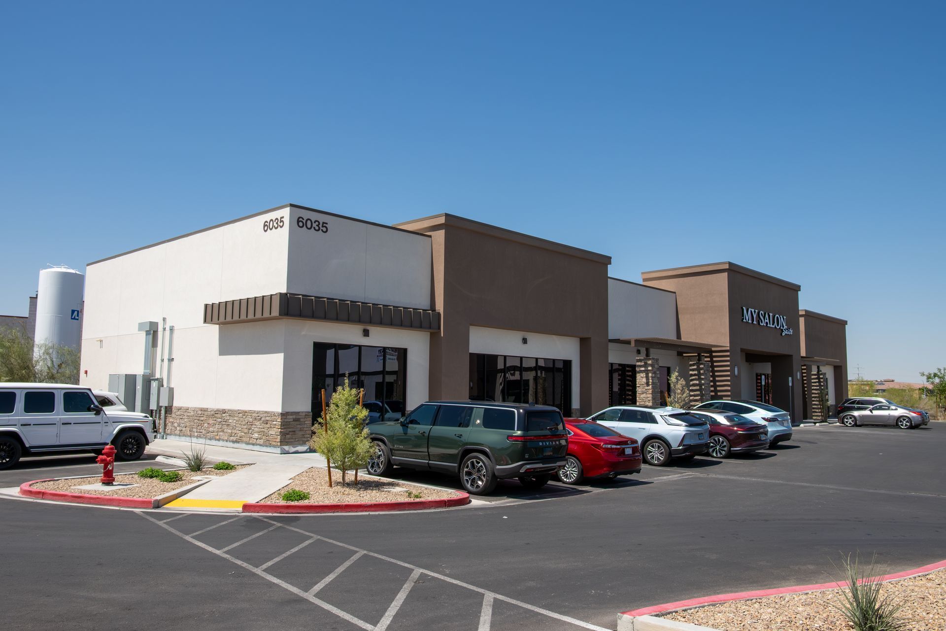 A lot of cars are parked in front of a building.