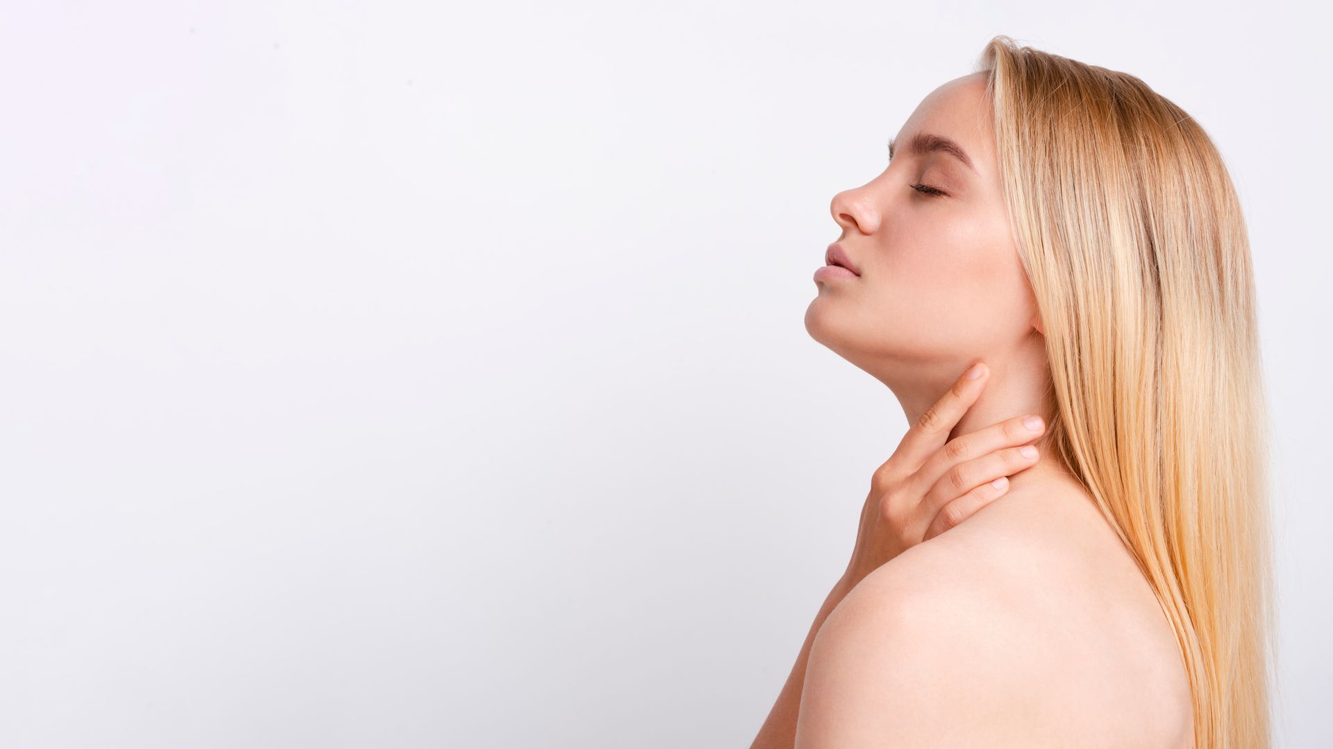 A woman touching her neck.
