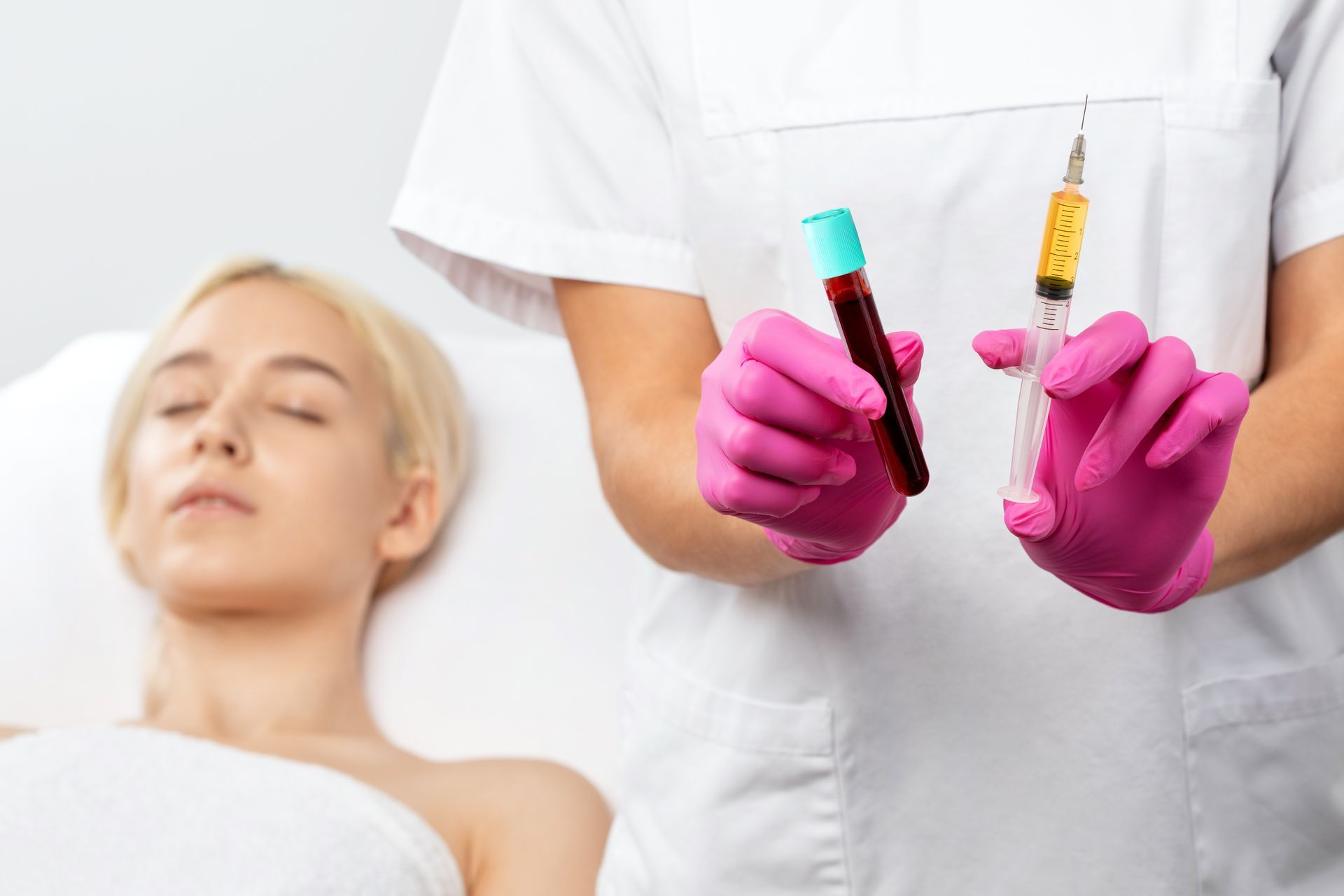 A patient lying in bed and a nurse holding a PRP injection next to her.