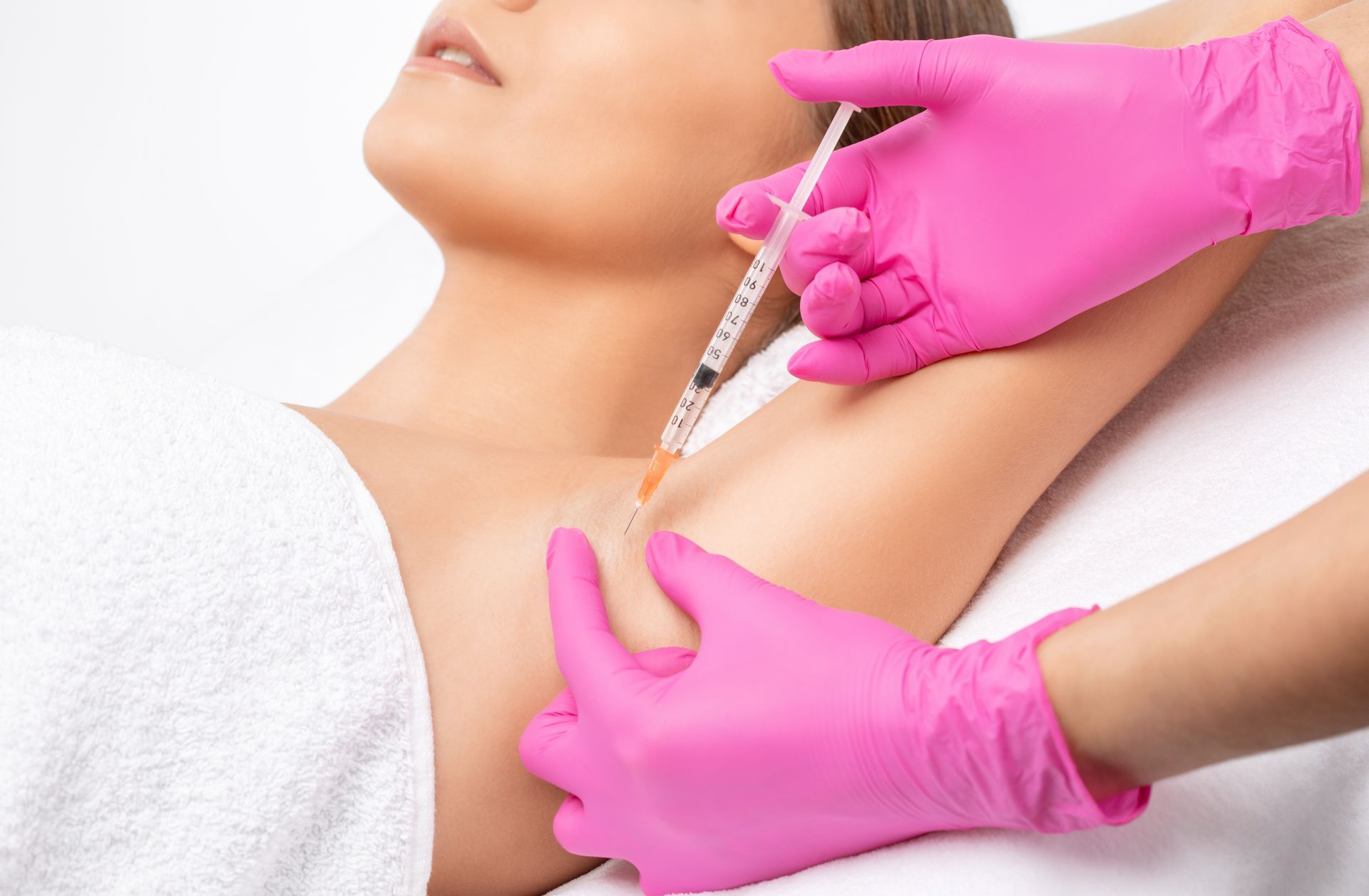 A woman is getting an injection in her armpit.