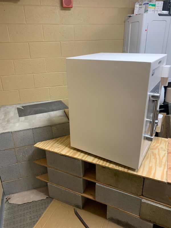 A white box is sitting on top of a wooden table in a room.