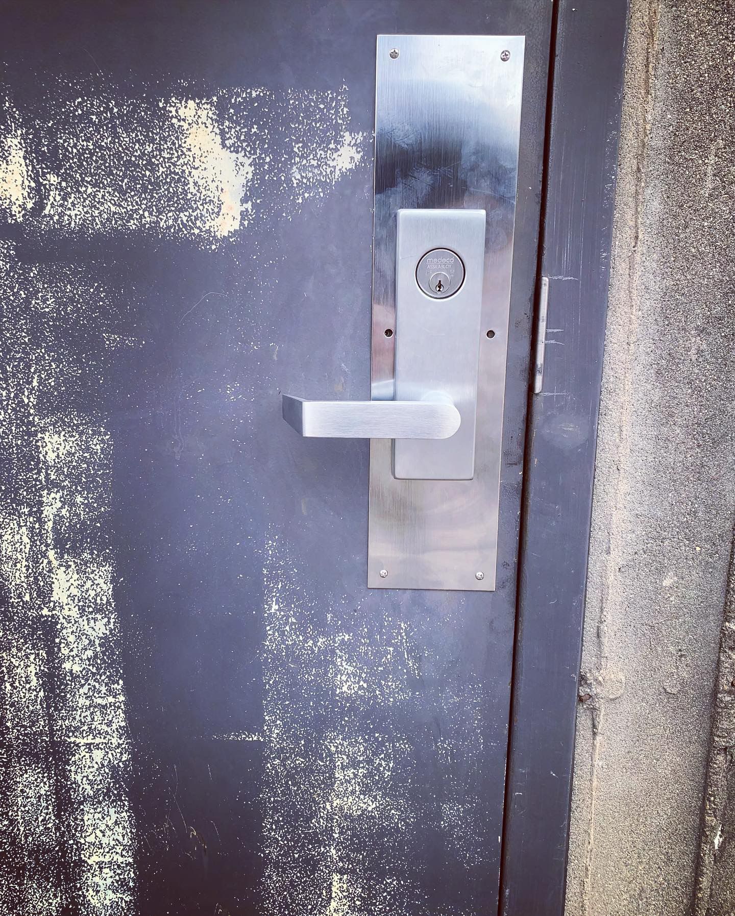 A dirty door with a stainless steel door handle