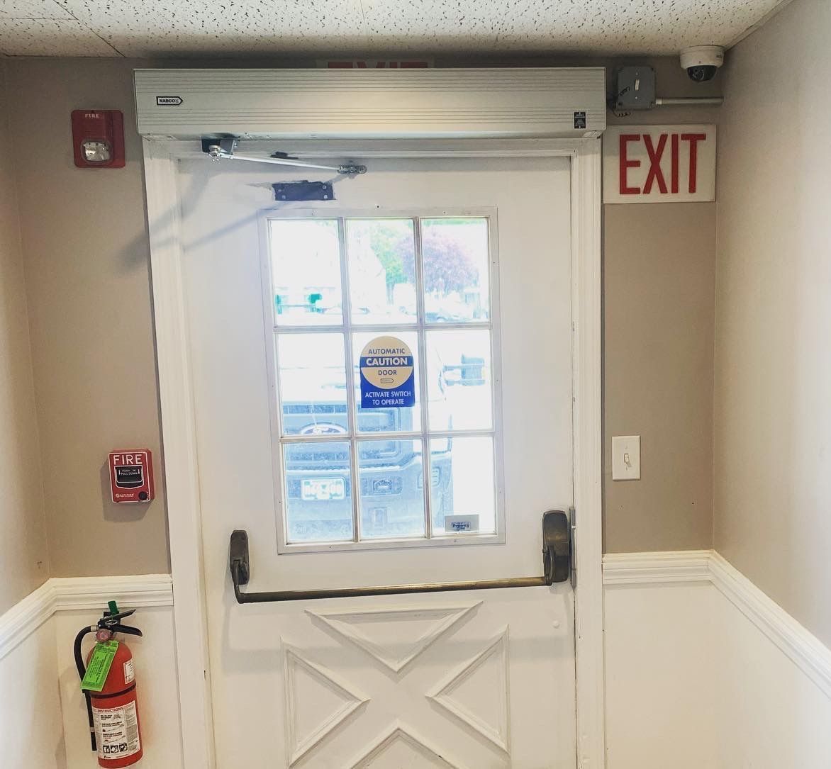 A white door with a red exit sign above it