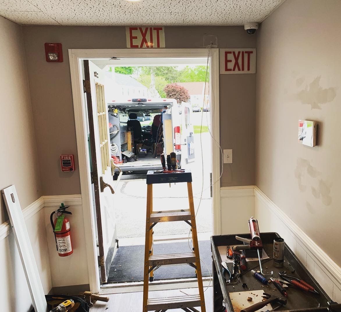 A ladder is sitting in front of an exit sign