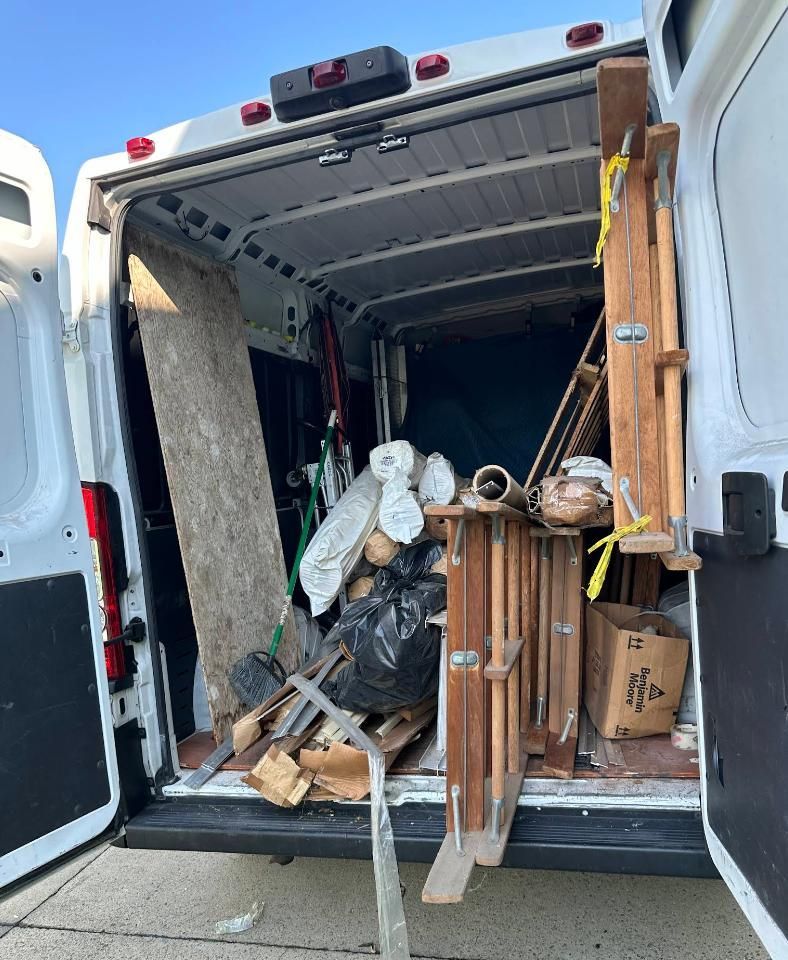 Open white van interior filled with debris.