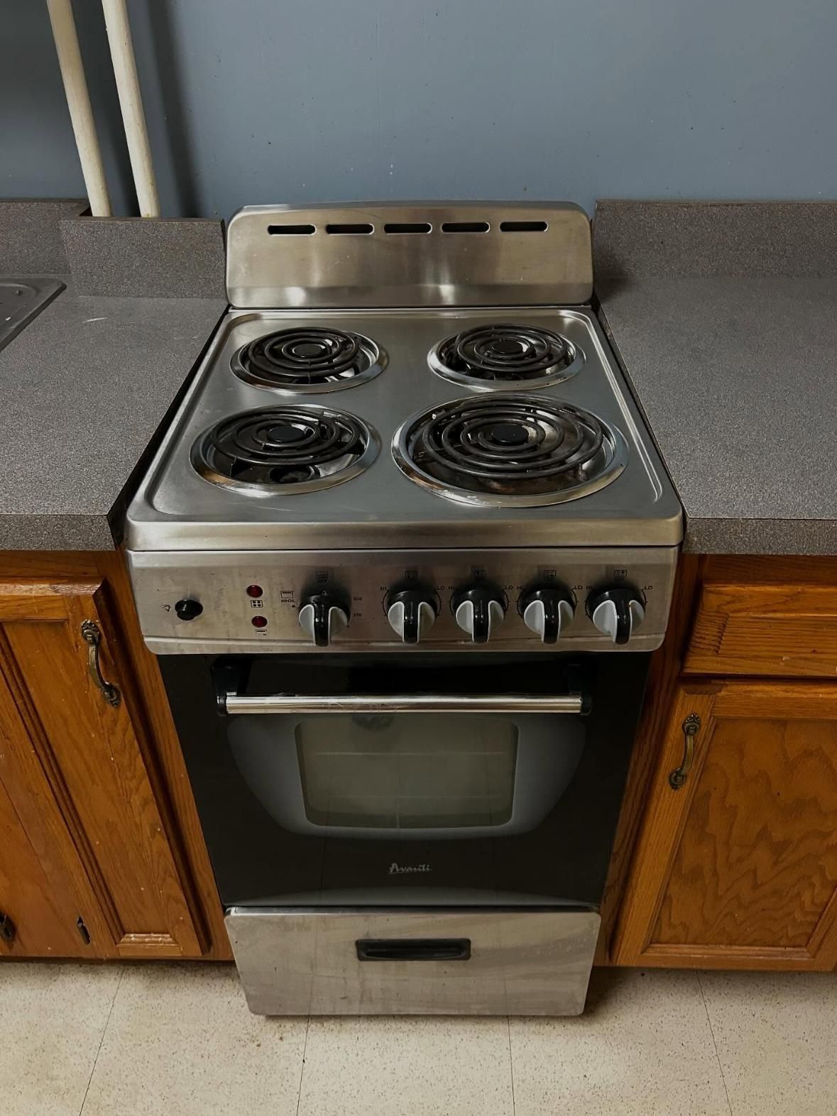Electric stove with four burners, stainless steel finish, and oven below.