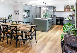 Dining table and chairs in the middle of the kitchen with hybrid flooring — Tiling Service in Winnellie, NT