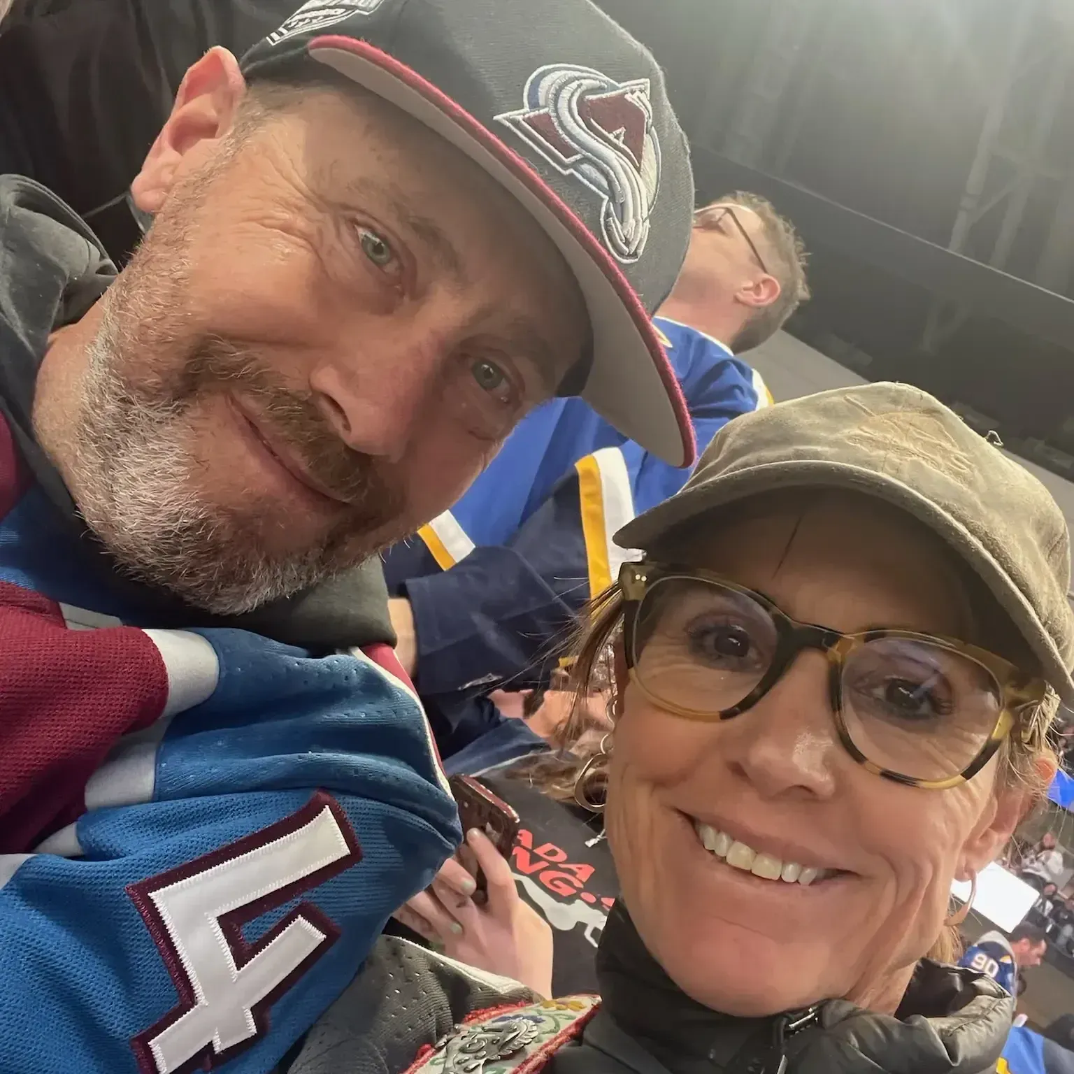 A man and a woman are posing for a picture and the man is wearing a jersey with the number 4 on it