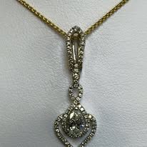 Gold necklace with a teardrop-shaped diamond pendant with surrounding smaller diamonds.