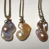 Three pearl pendant necklaces with different colored large baroque pearls on silver chains.
