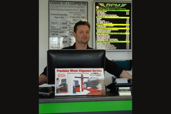 Man RPM In Front Of Tire & Auto Center Desk — Fairless Hills, PA — RPM Tire & Auto Center