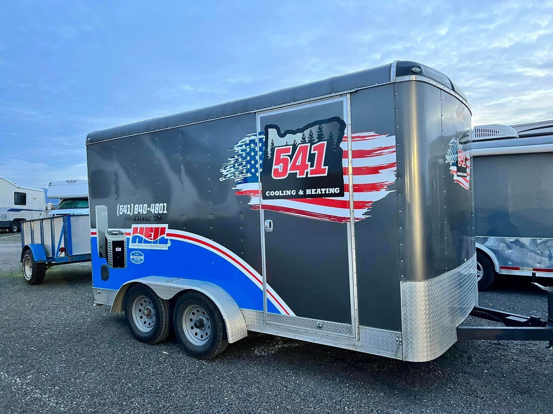 A trailer with an american flag on it is parked in a parking lot.