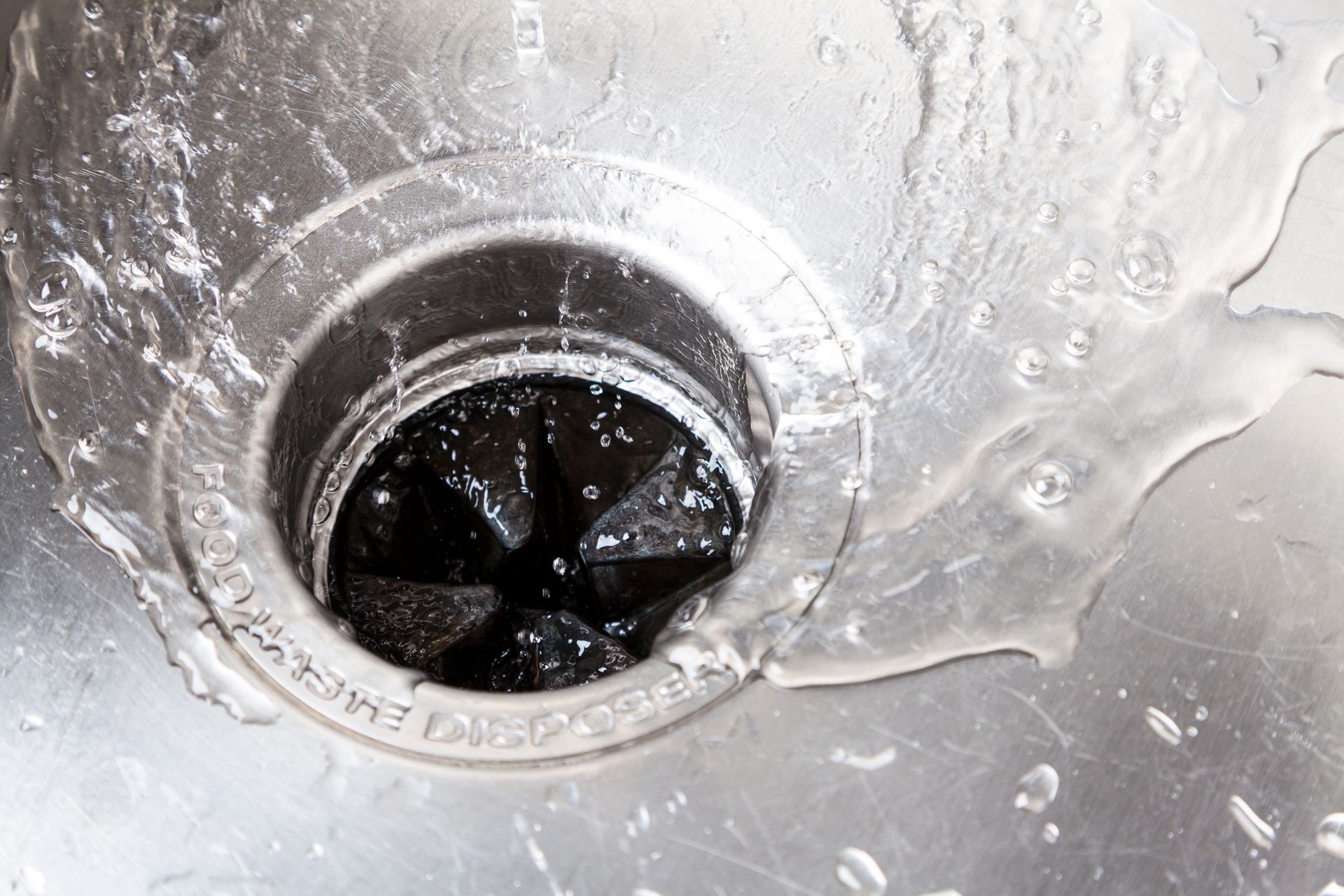 A close up of a sink drain with water coming out of it.