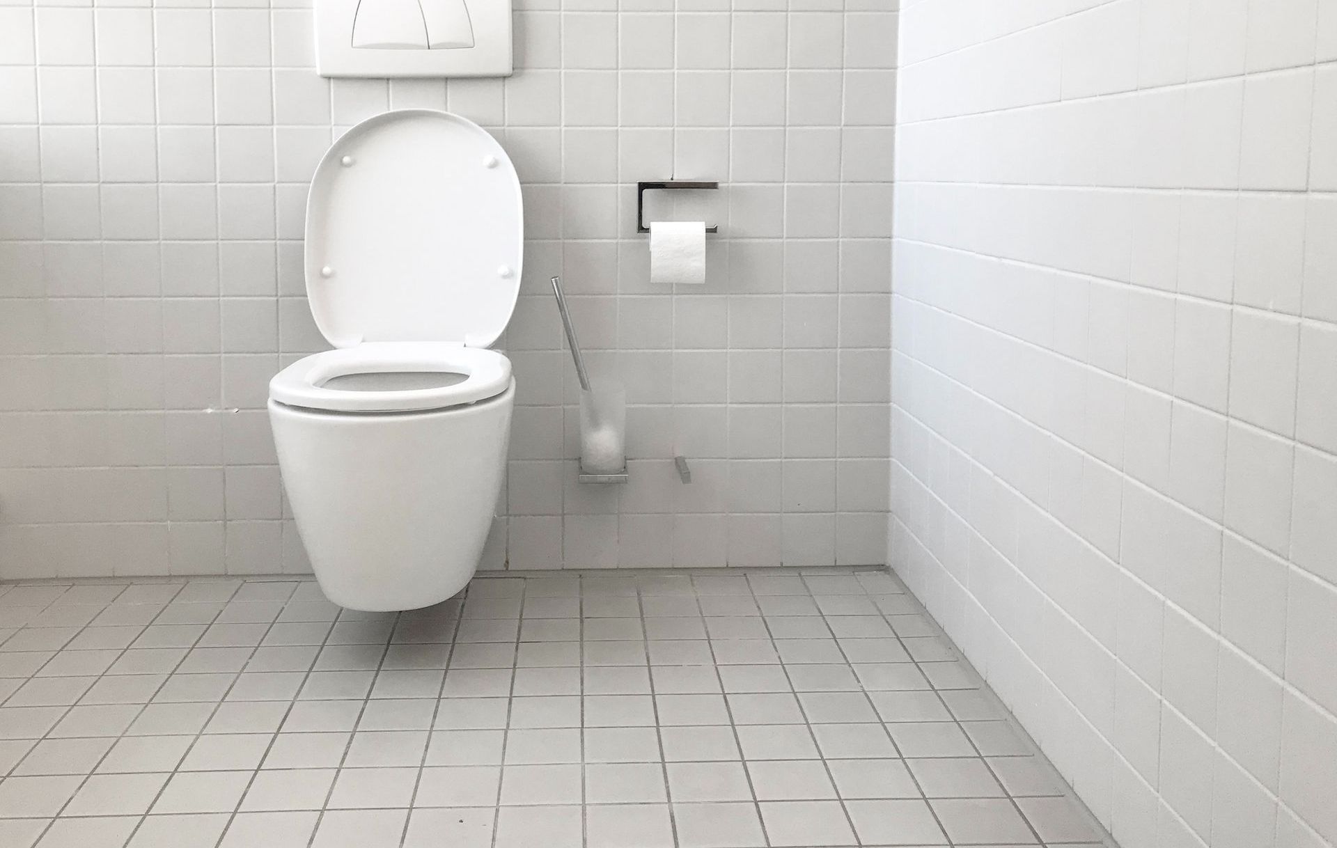 A white toilet is hanging from the wall in a bathroom.