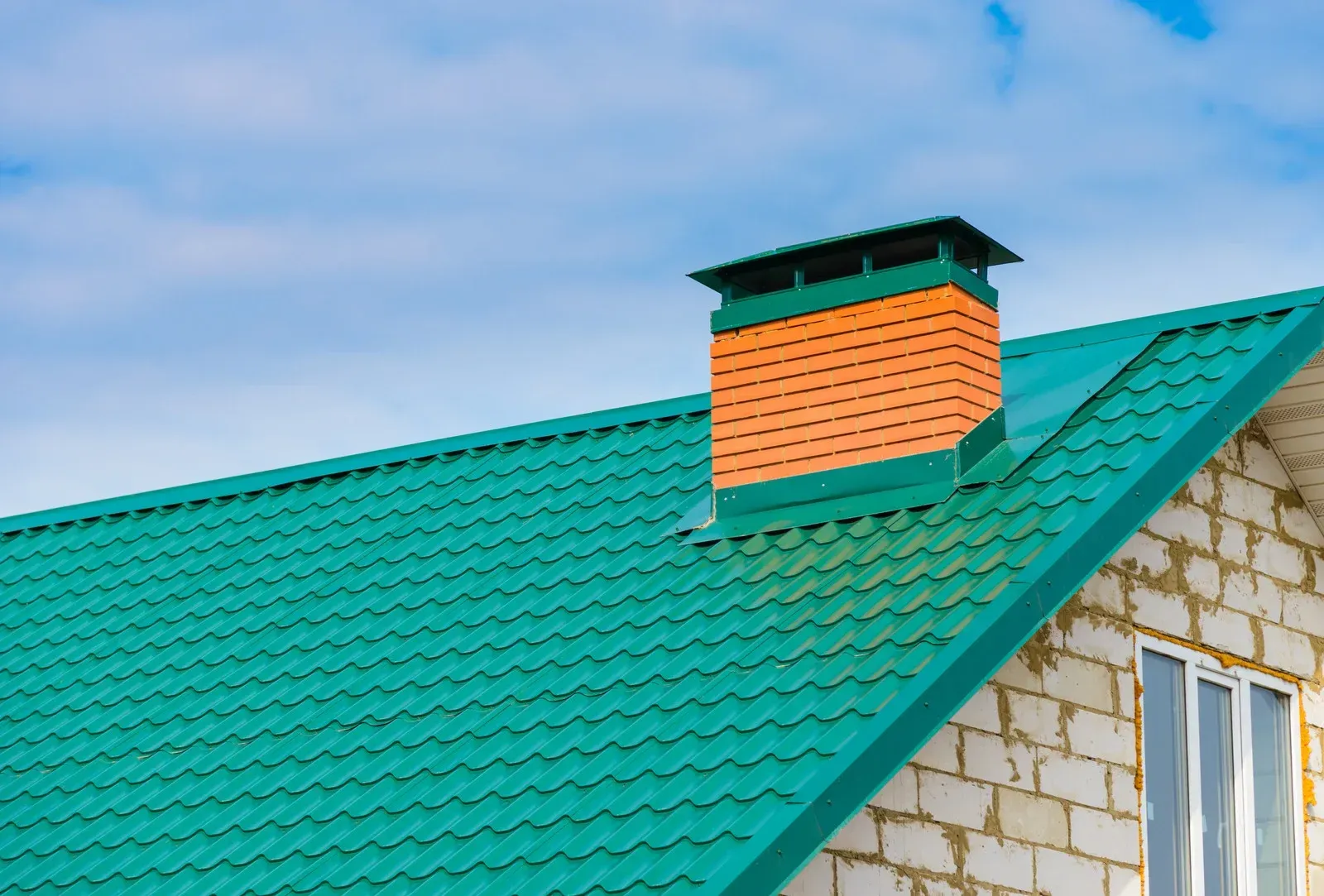 A green roof with a chimney on top of it.