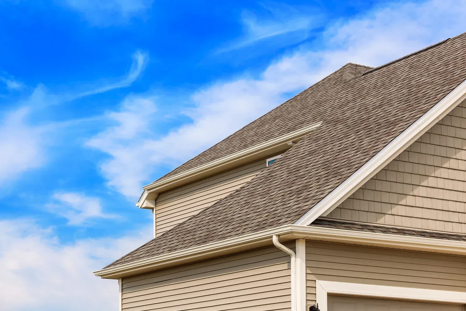 The roof of a house with a blue sky in the background.
