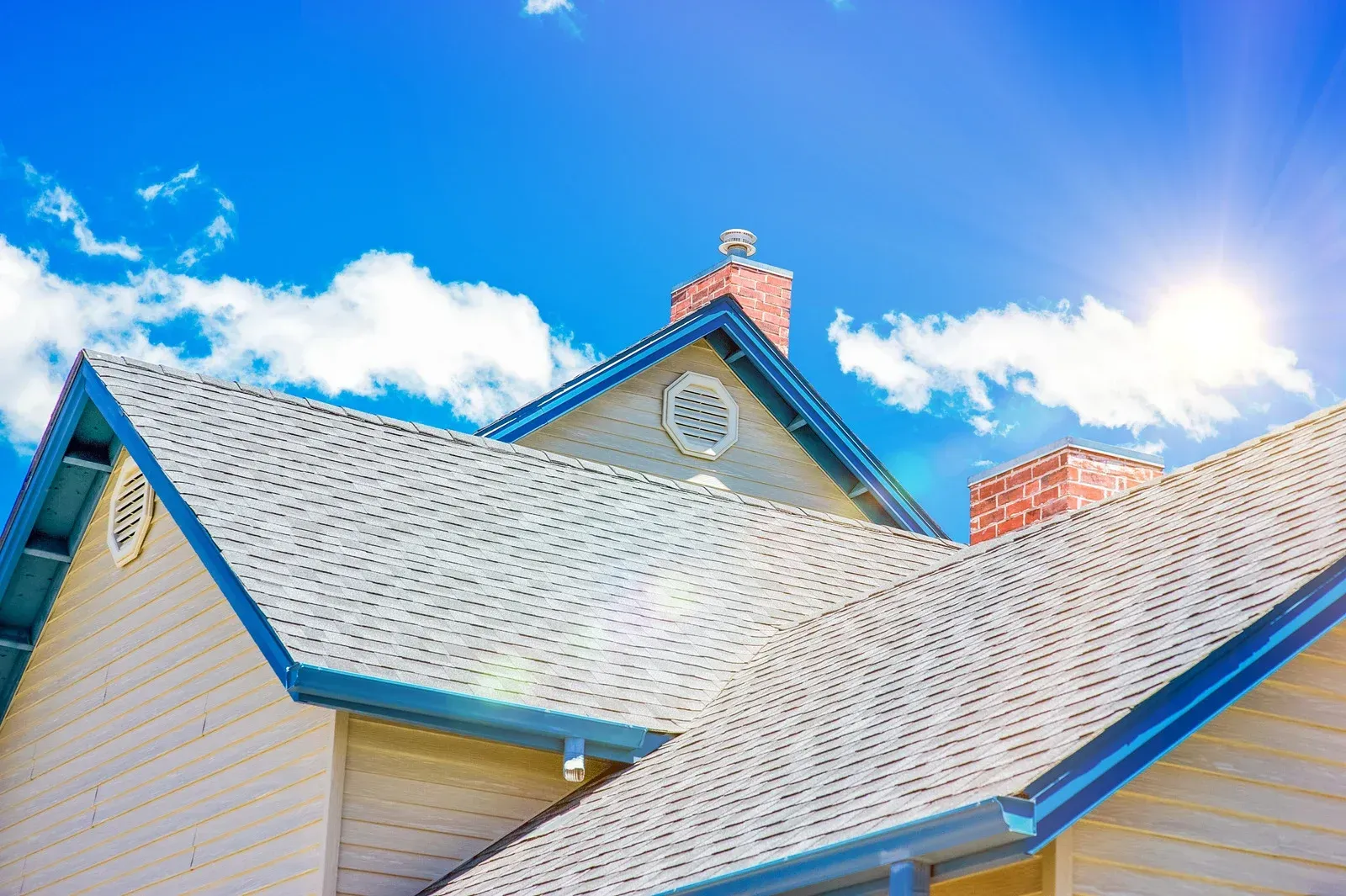 The sun is shining on the roof of a house.
