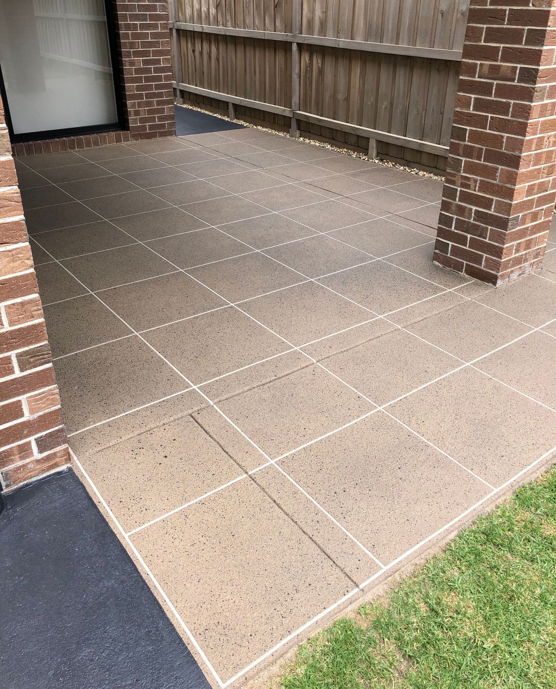 A brick driveway leading to a house surrounded by trees