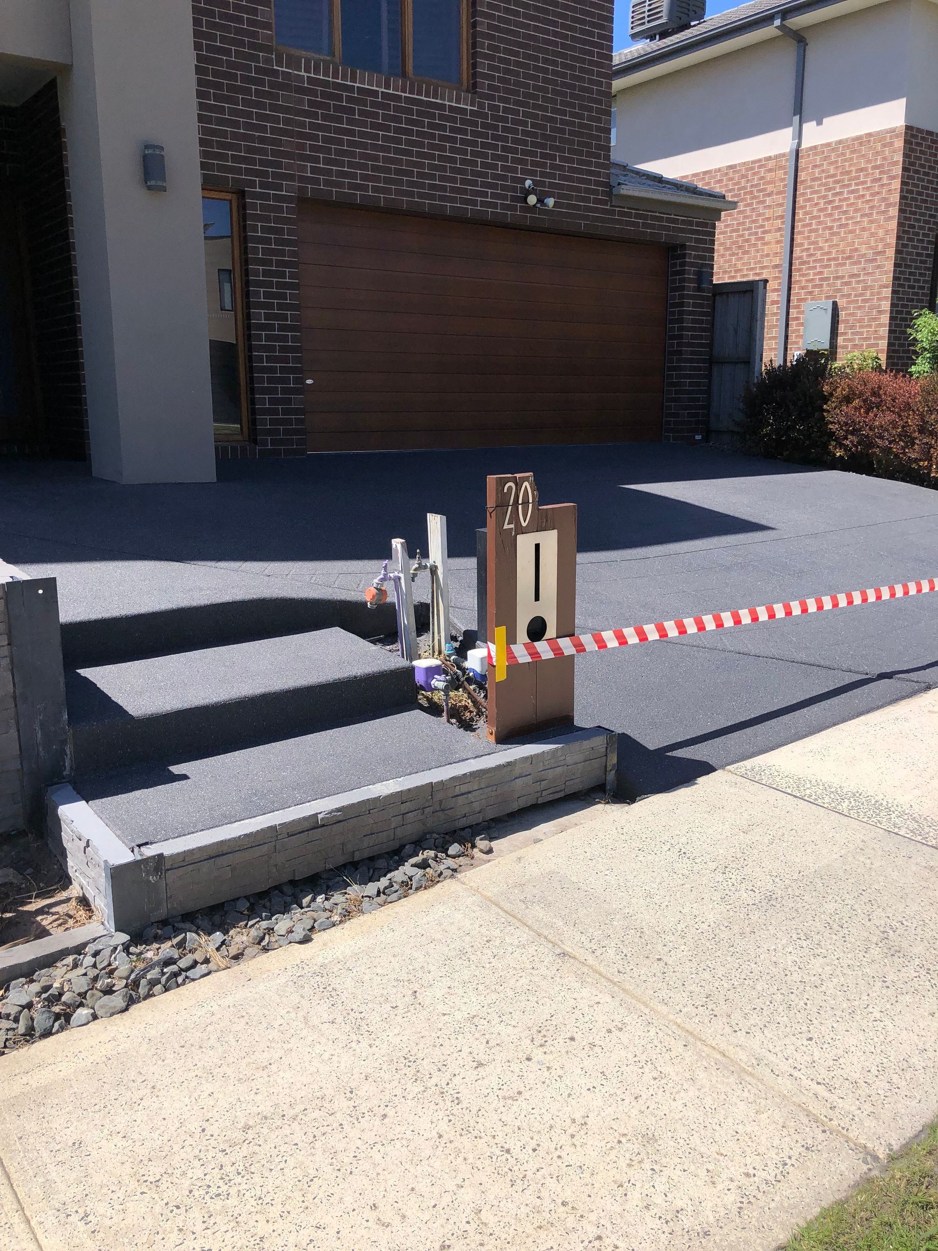 A patio with a brick wall and a concrete floor.