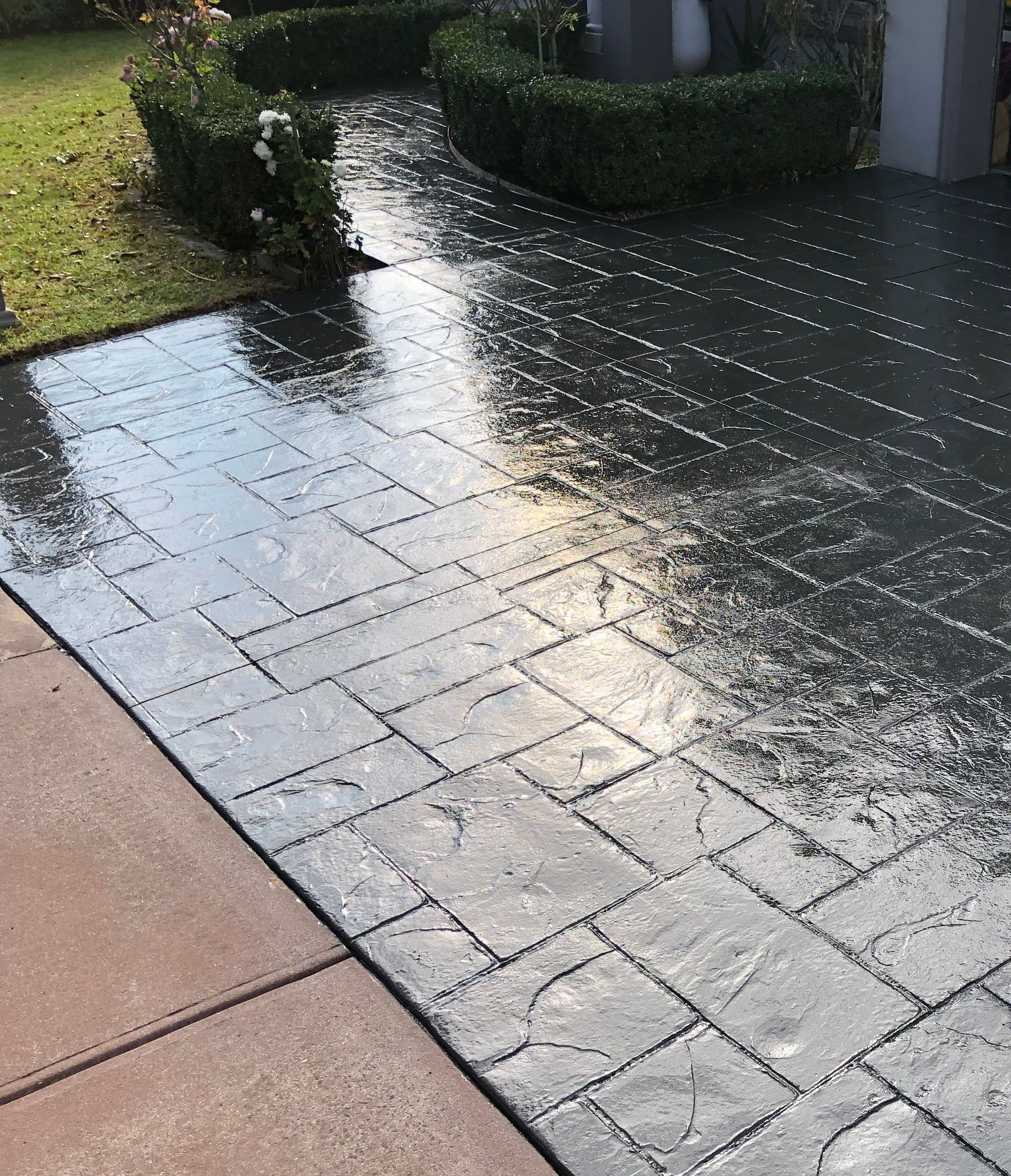 A red and white tape is covering a brick driveway in front of a house.