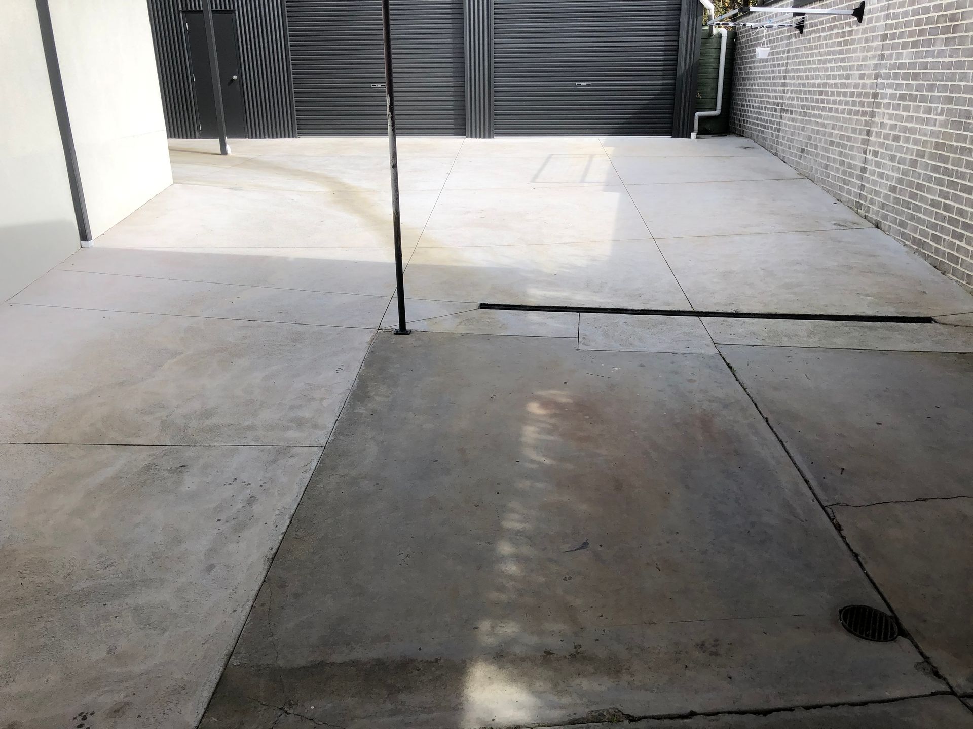 A person is using a high pressure washer to clean a brick floor.