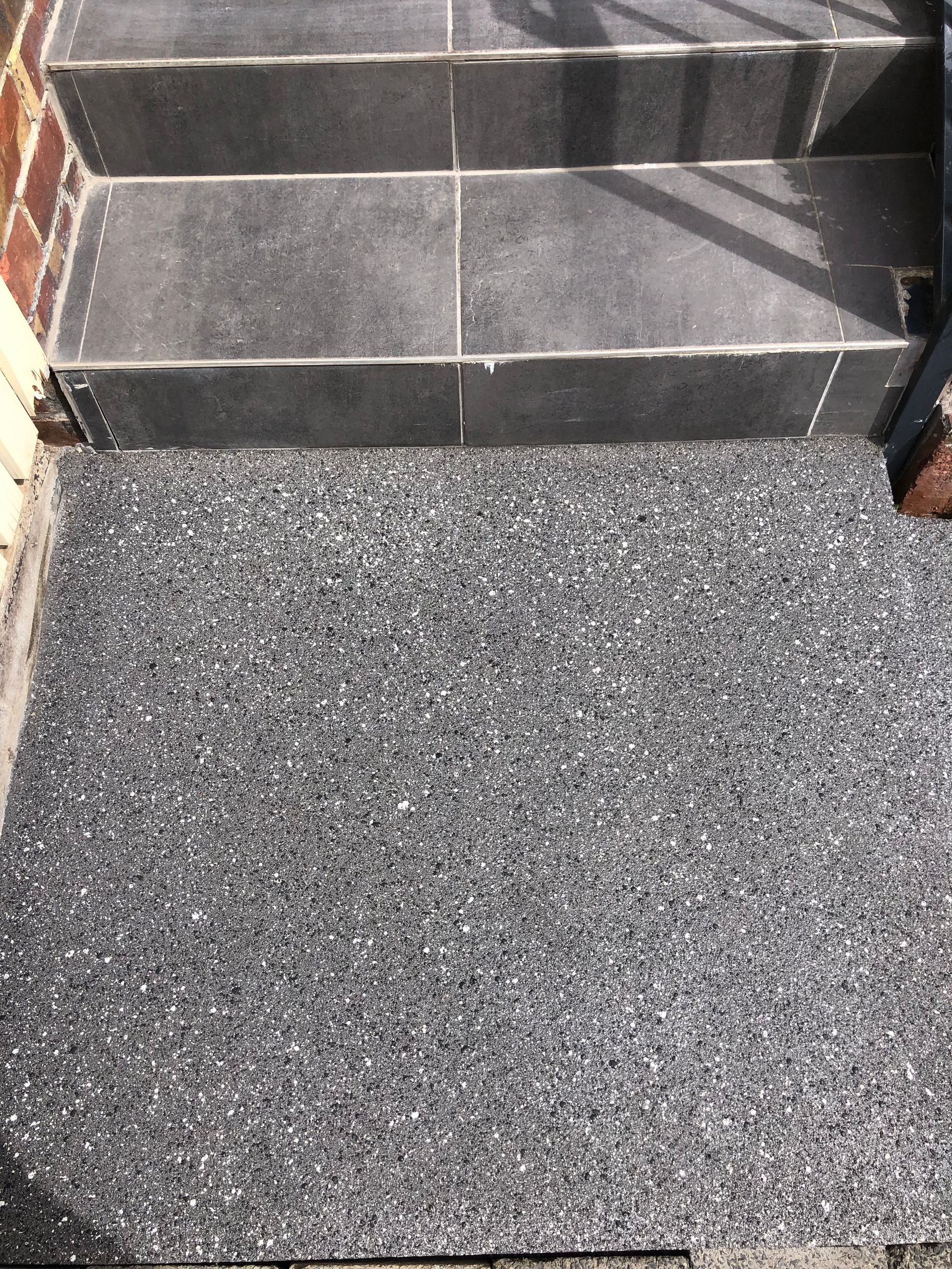 A man wearing a hard hat and safety vest is using a trowel on a concrete surface.