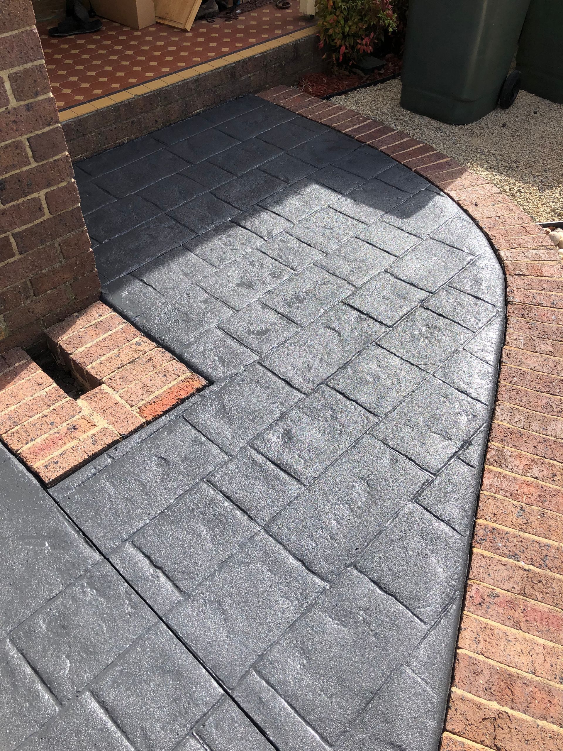 A concrete porch with brick steps leading to it