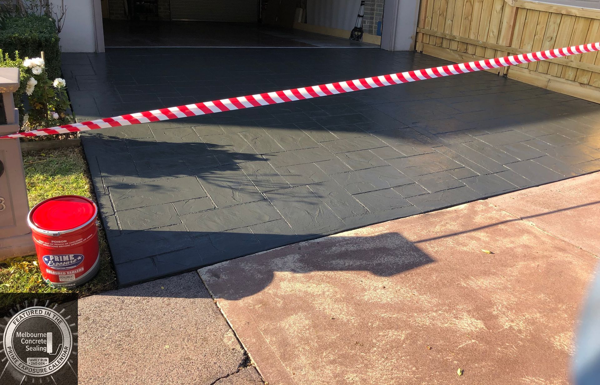 A patio with a bench and a brick wall in the background.