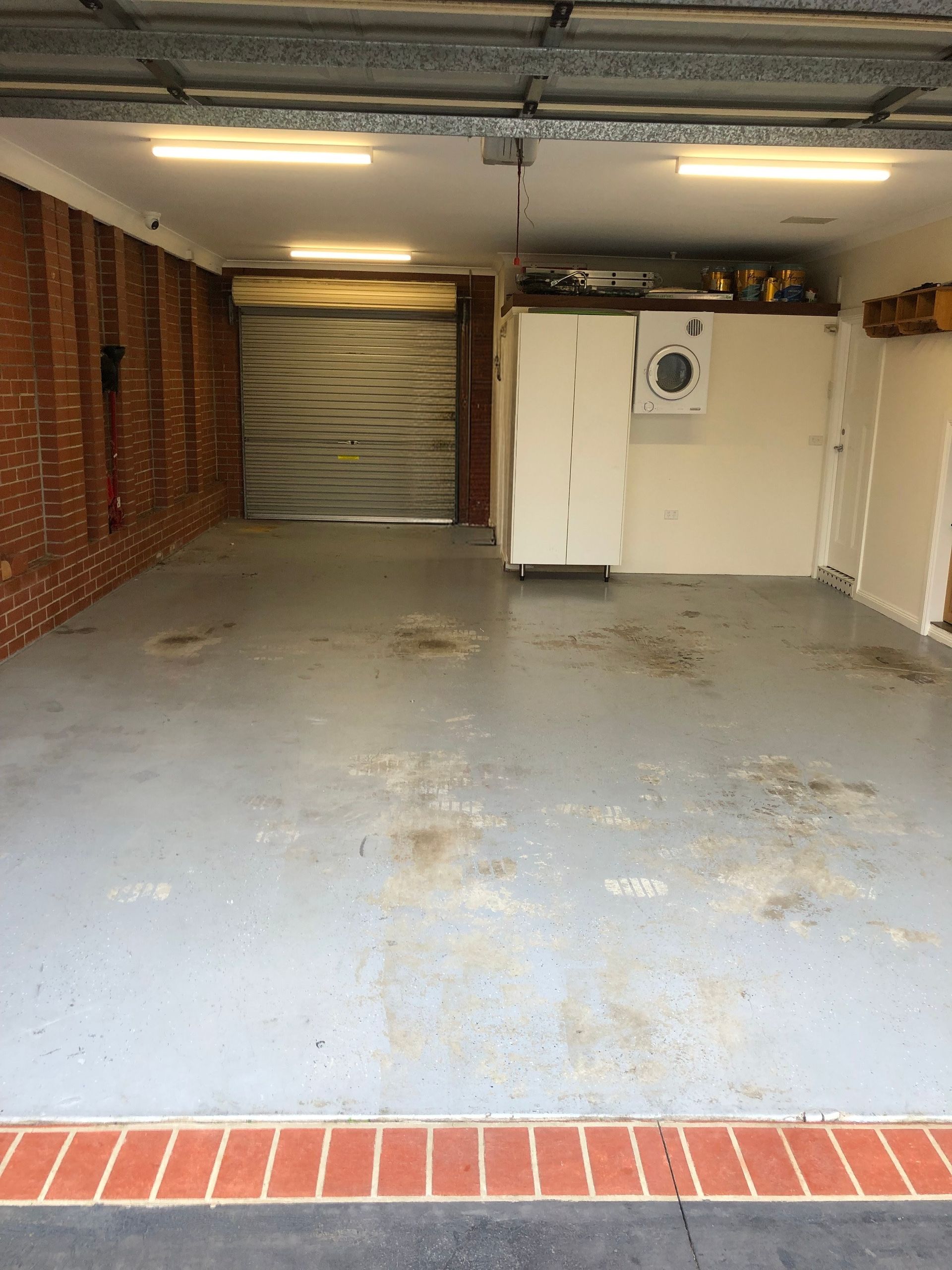 Worn garage concrete floor before Signature Stunning Epoxy System installation in Aspendale by Melbourne Concrete Sealing and Resurfacing.