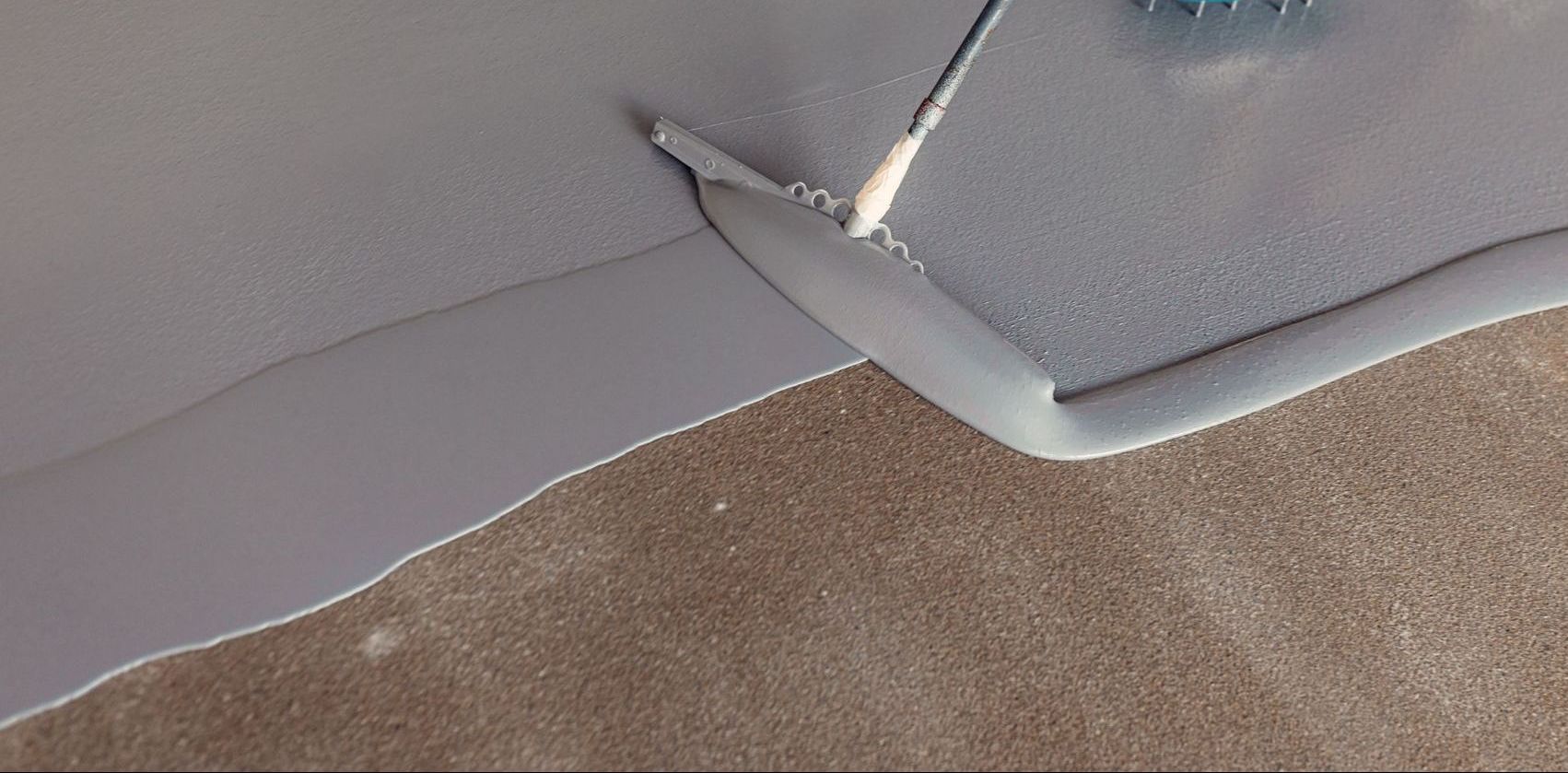 Applying Epoxy flooring to garage with squeegee 