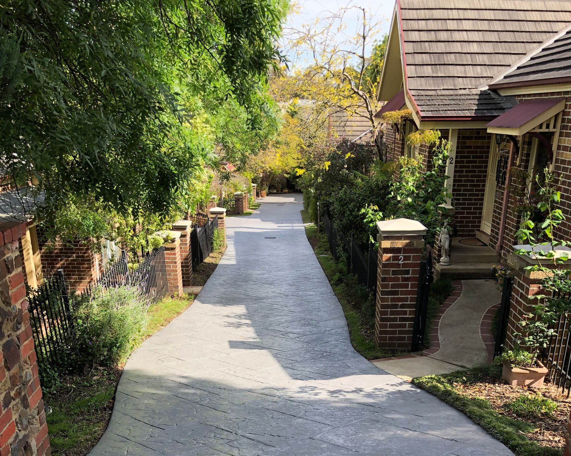 A tiled walkway with a brick wall in the background.