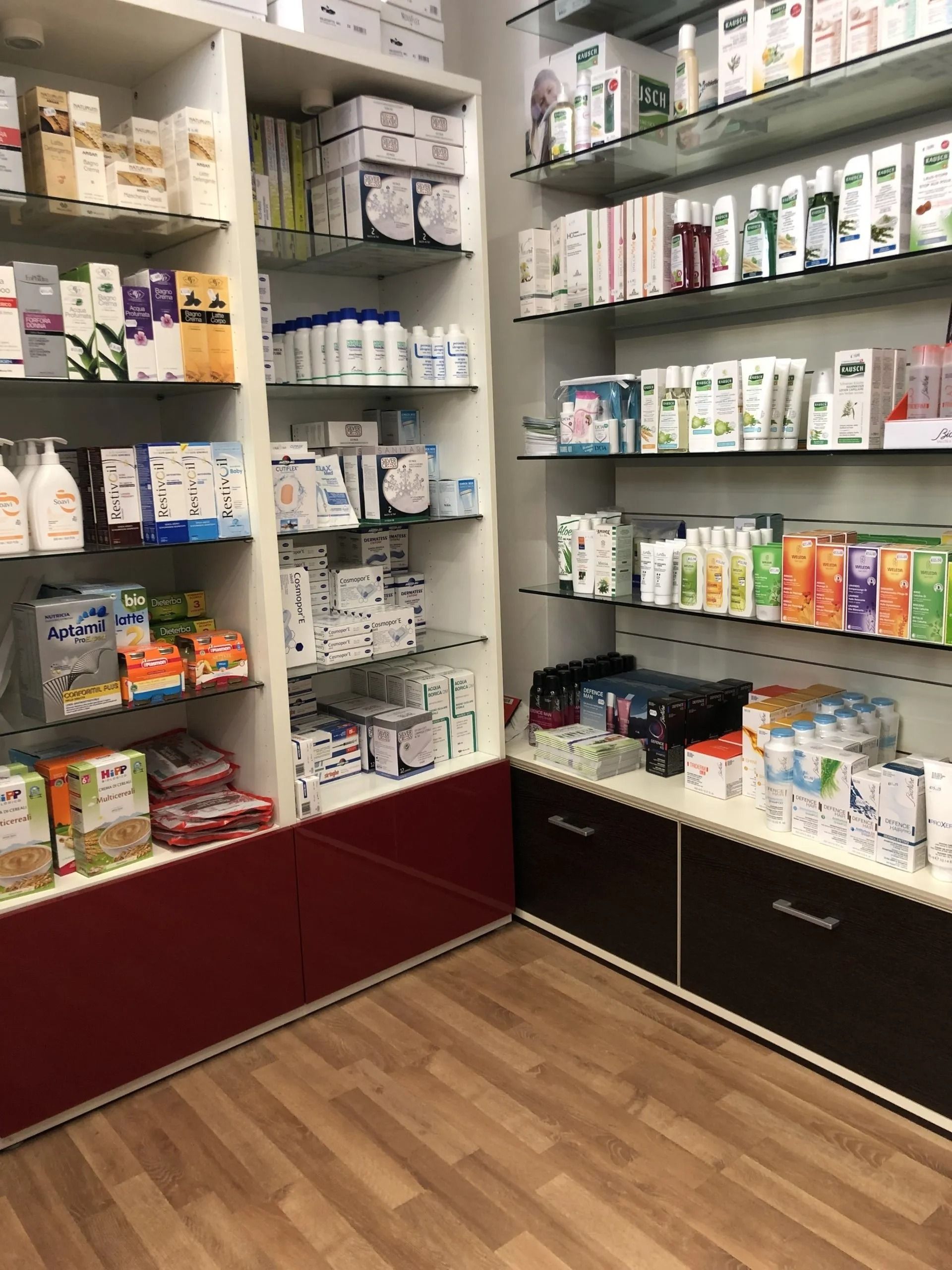 Scaffali di una farmacia riforniti con vari prodotti per la cura della pelle, l'igiene e il benessere.