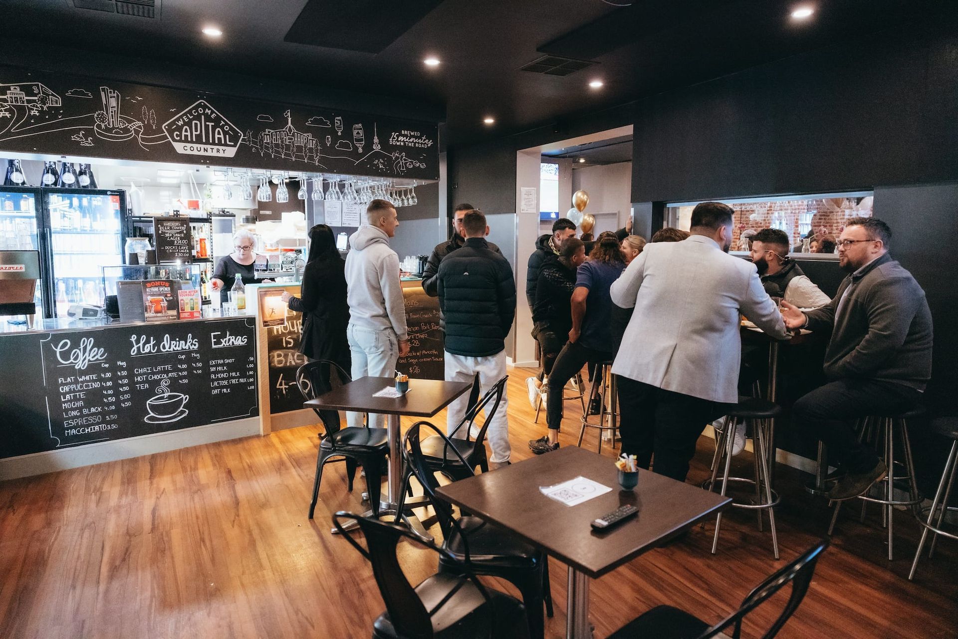 A group of people are sitting at tables in a restaurant.