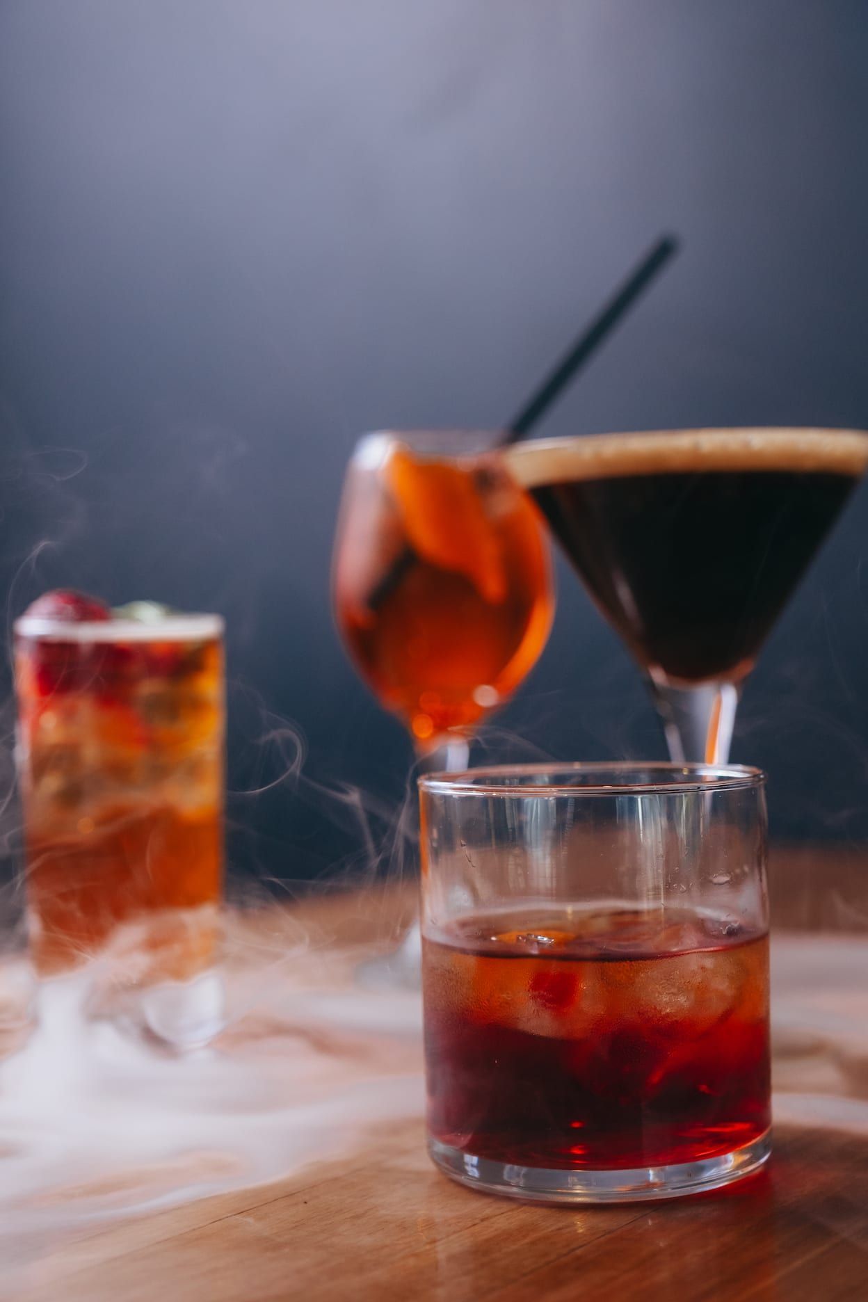 Three different types of drinks are sitting on a wooden table.