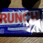 A crunch bar is sitting on a wooden table.