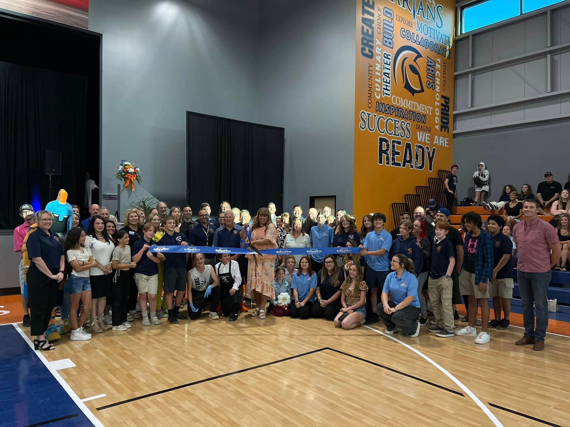 A group of people are posing for a picture on a basketball court.
