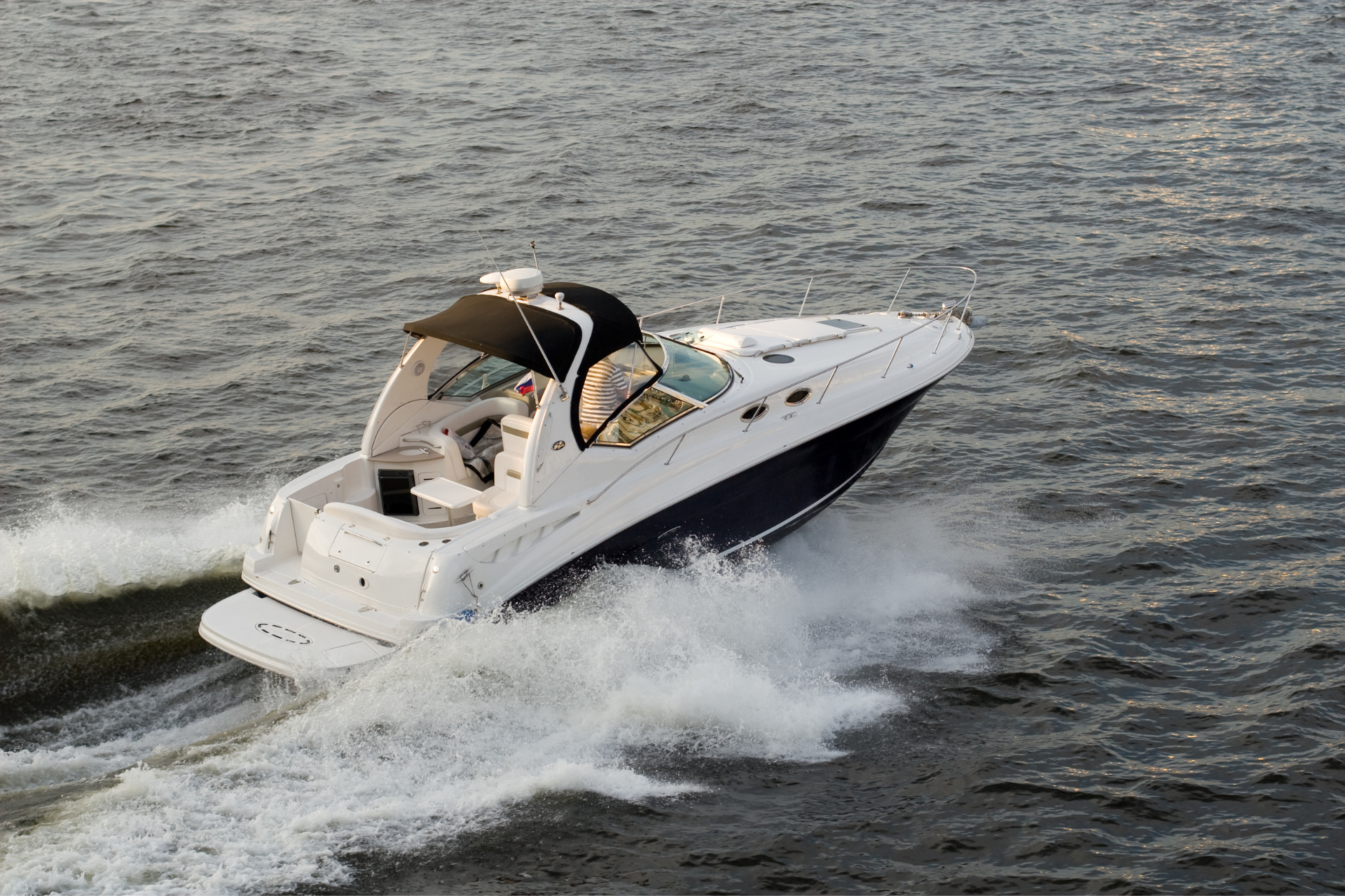 A white and black boat is floating on top of a body of water.