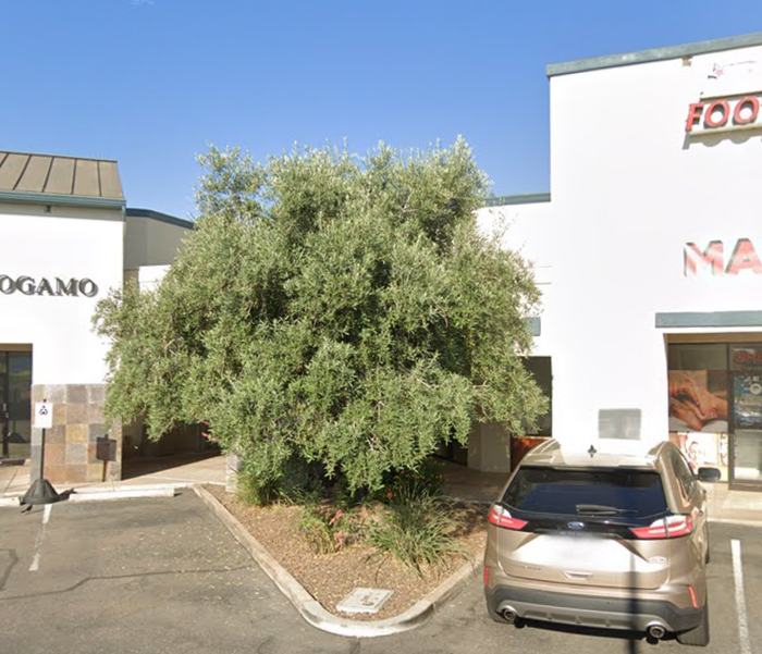 A car is parked in front of a building that says amo