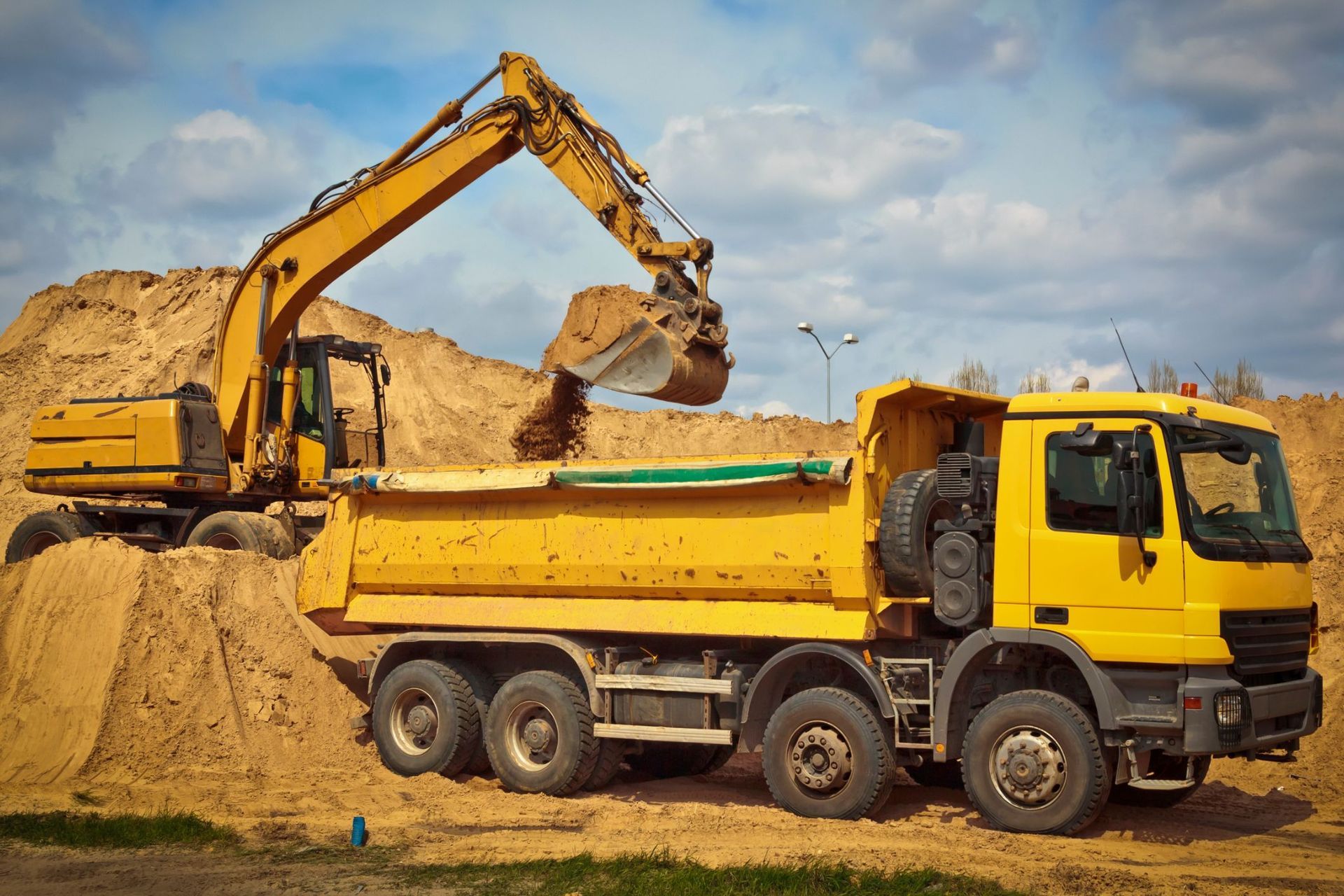 A construction worker is standing in front of a crane on a construction site.
