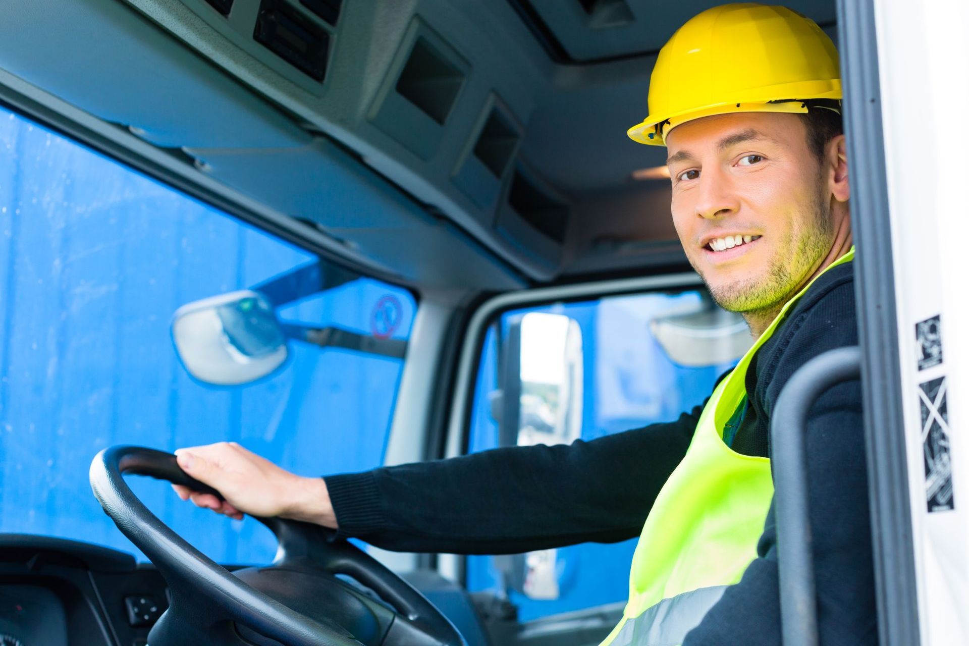 A construction worker is standing in front of a crane on a construction site.