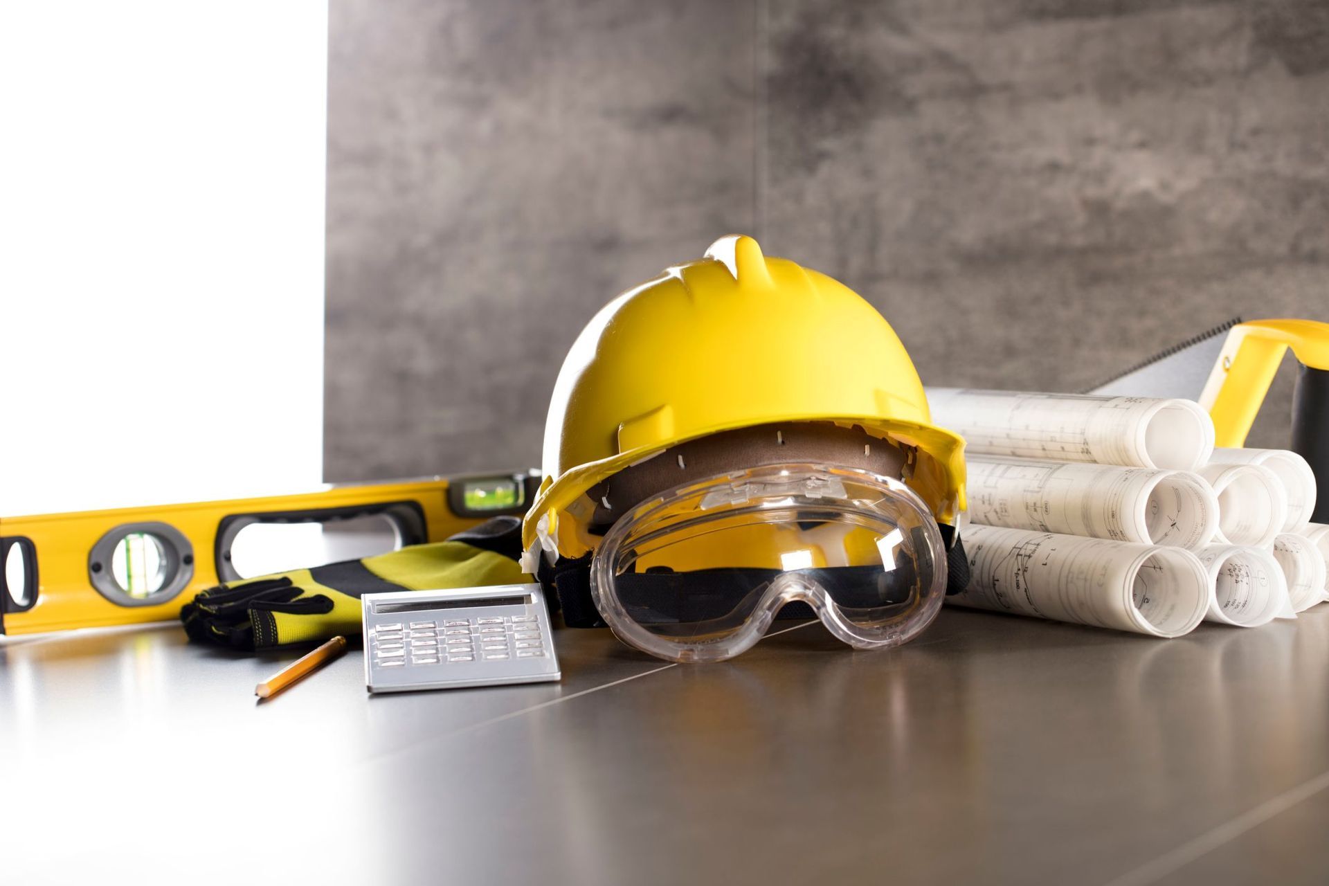 A construction worker is standing in front of a crane on a construction site.