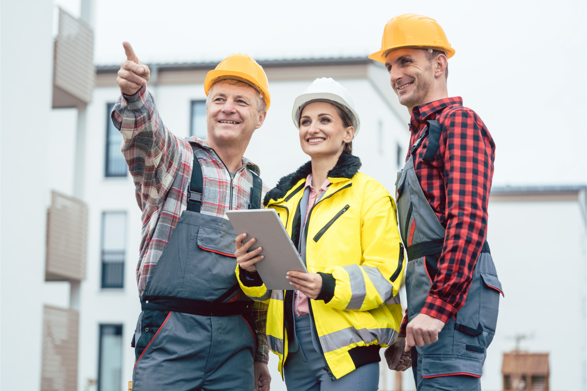 A construction worker is standing in front of a crane on a construction site.