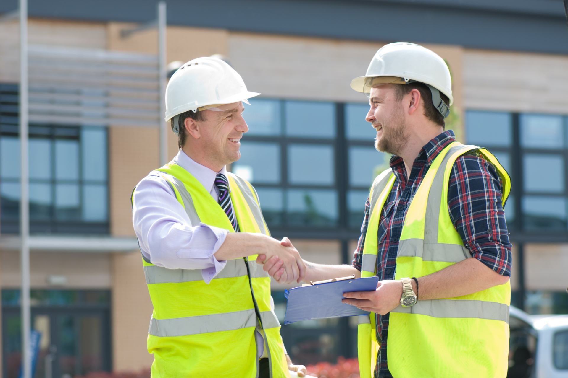 A construction worker is standing in front of a crane on a construction site.