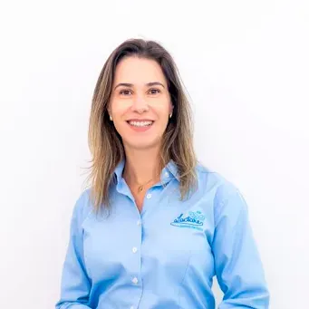 Uma mulher de camisa azul está sorrindo para a câmera.