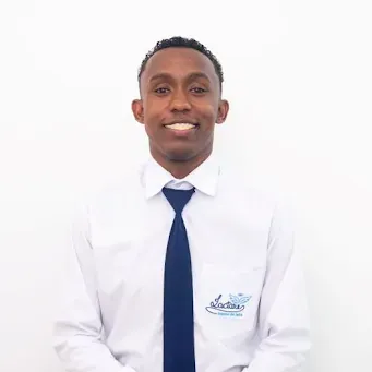 Um homem vestindo uma camisa branca e gravata azul está sorrindo para a câmera.