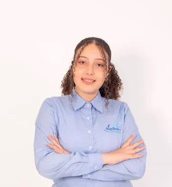 Uma mulher de camisa azul está de pé com os braços cruzados.