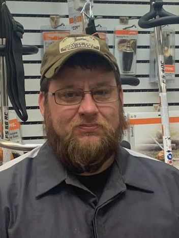 A man with a beard wearing a hat and glasses