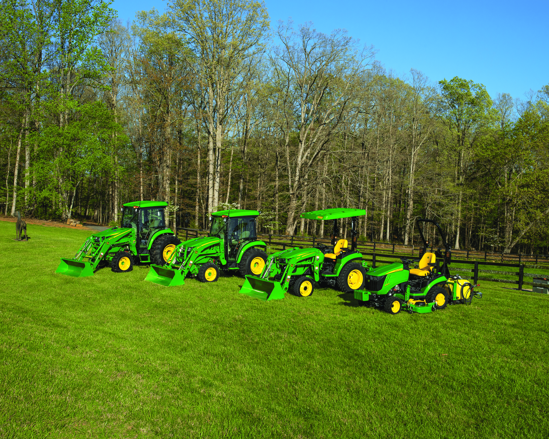 A woman is riding a john deere lawn mower on a lush green lawn.