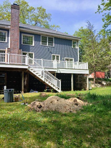 The back of a house with a large deck and stairs.