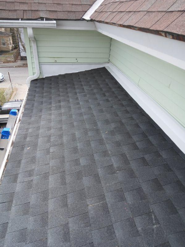 The roof of a house with a black shingle roof.